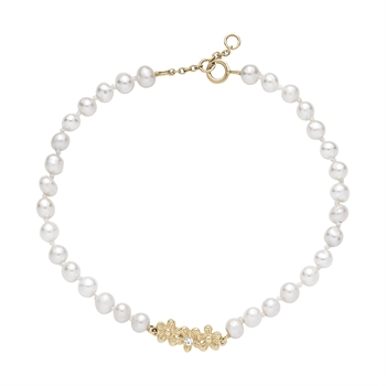 Bracelet with freshwater pearls, gold floral clasp, and zirconia stone on a white background.