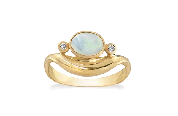 Gold ring with oval opal, two clear stones, and wave-like band design.
