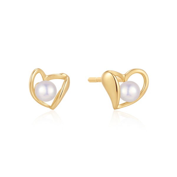 Gold heart-shaped earrings with pearl centers, shiny finish, reflecting light.