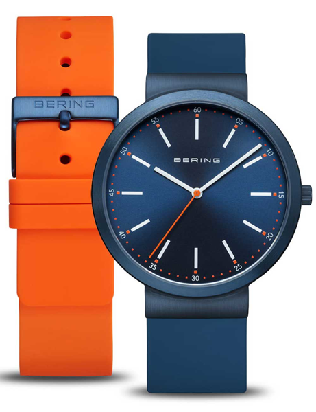 Bering watch with blue dial, white markers, orange second hand, and extra orange strap.