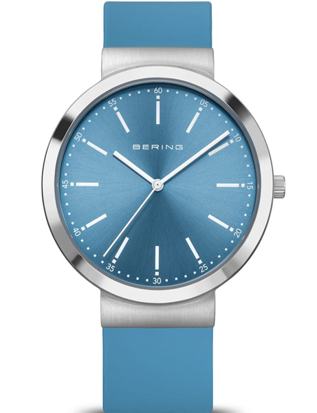 Blue-dial watch with silver bezel, minimalist markers, and matching blue strap. Elegant design.