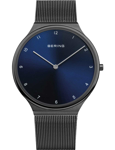Minimalist Bering men\'s watch with deep blue dial, mesh band, and brand name "BERING" on the face.
