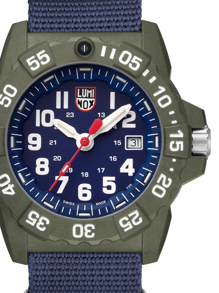 Navy blue watch face with white numbers, date at 3 o\'clock, and a green rotating bezel.