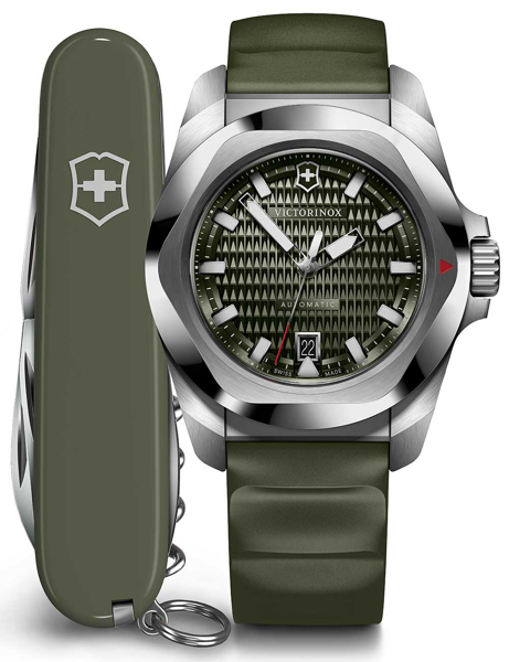 Green dial Victorinox watch with luminescent hands, hexagonal bezel, date at 6, next to a Swiss Army knife.