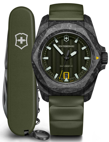 Green Victorinox watch with textured bezel, luminescent markers, date at 6. Swiss Army knife beside.