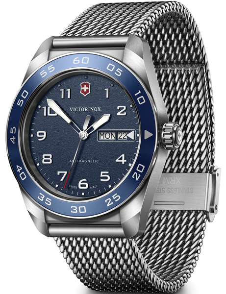 Blue dial watch with large numerals, day/date, blue bezel, and stainless steel mesh bracelet.